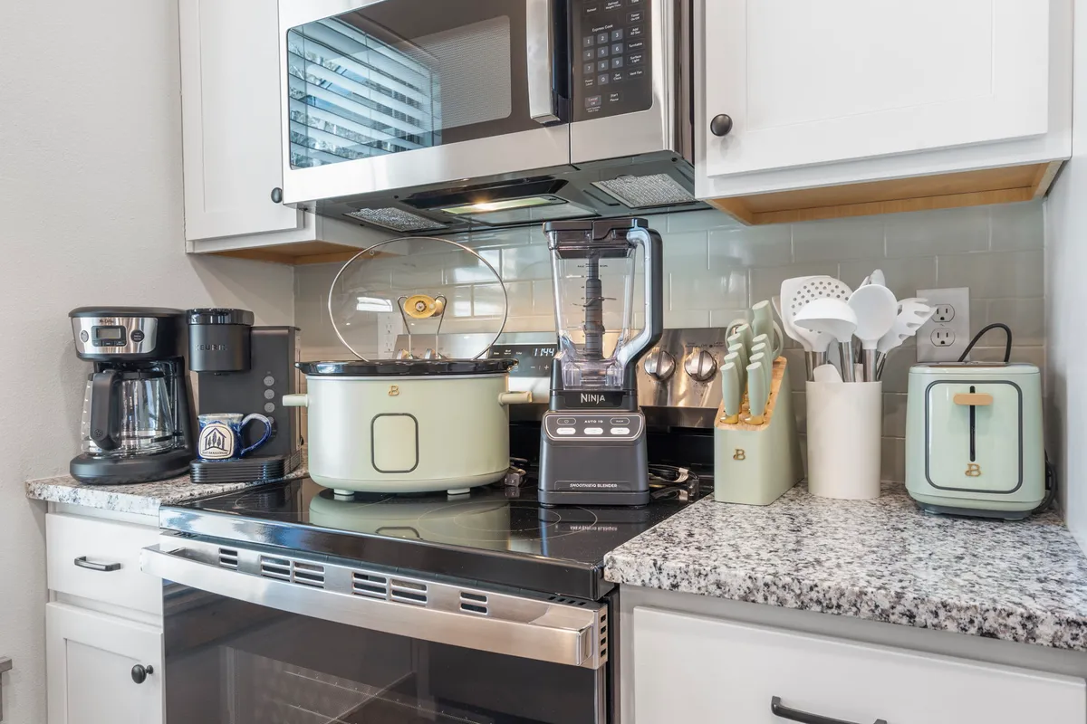 A modern kitchen with sleek white cabinetry, granite countertops, and updated appliances. The open design and ample counter space invite meal preparation and social cooking, while the cozy mood makes it feel like the heart of the home.